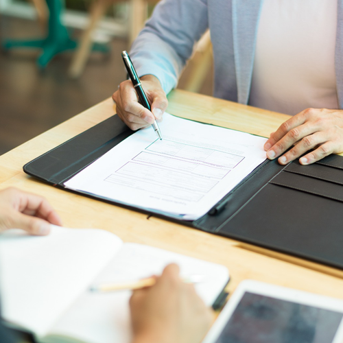 HR manager signing documents for human resource management system software with digital HRMS features